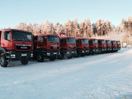 Водитель мана. Четырех остный ман рядом с автомобилем.